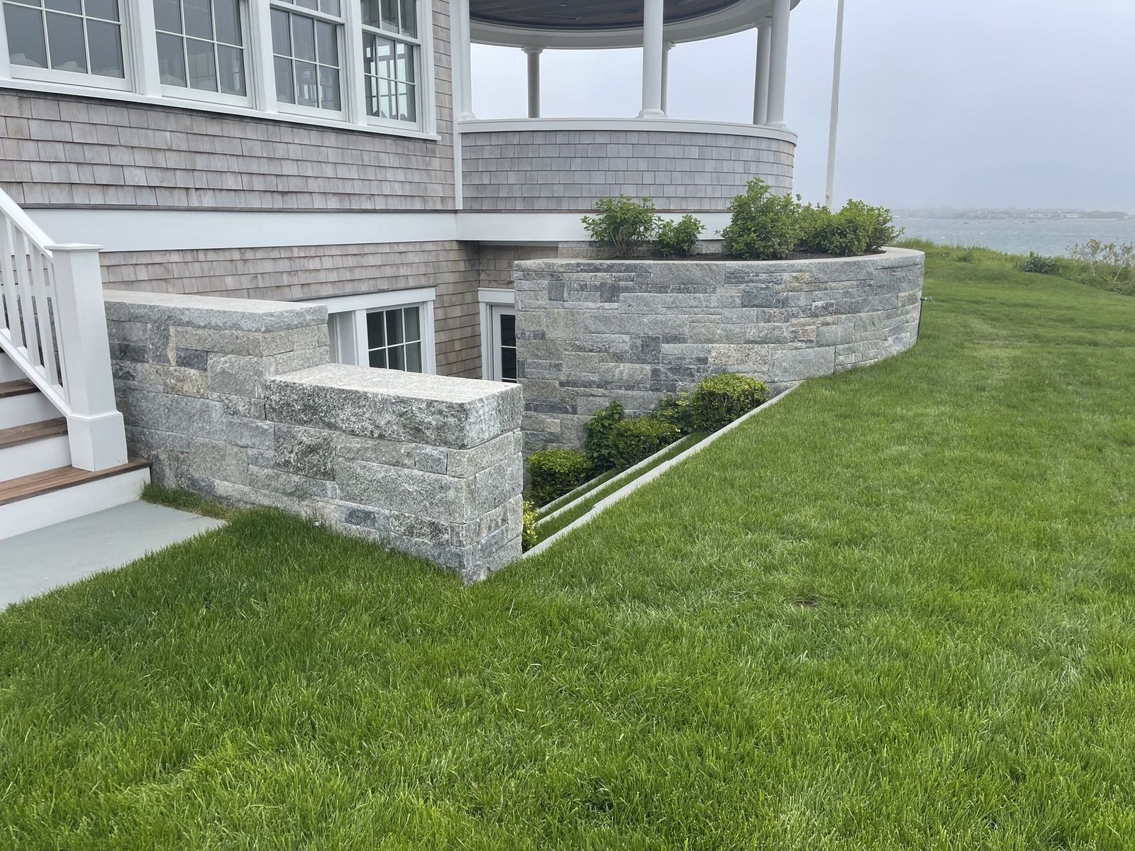 Hand-set fieldstone wall and stone steps on a Cape Cod property by Blue Claw Associates